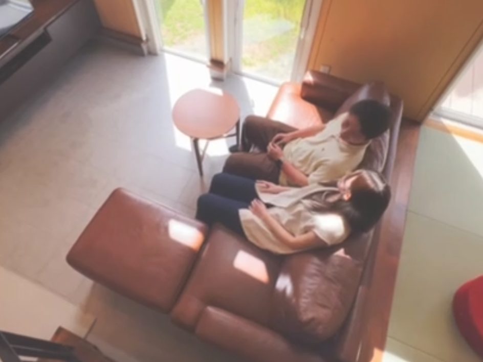 ソファでくつろぎながら住み心地を確かめる夫婦